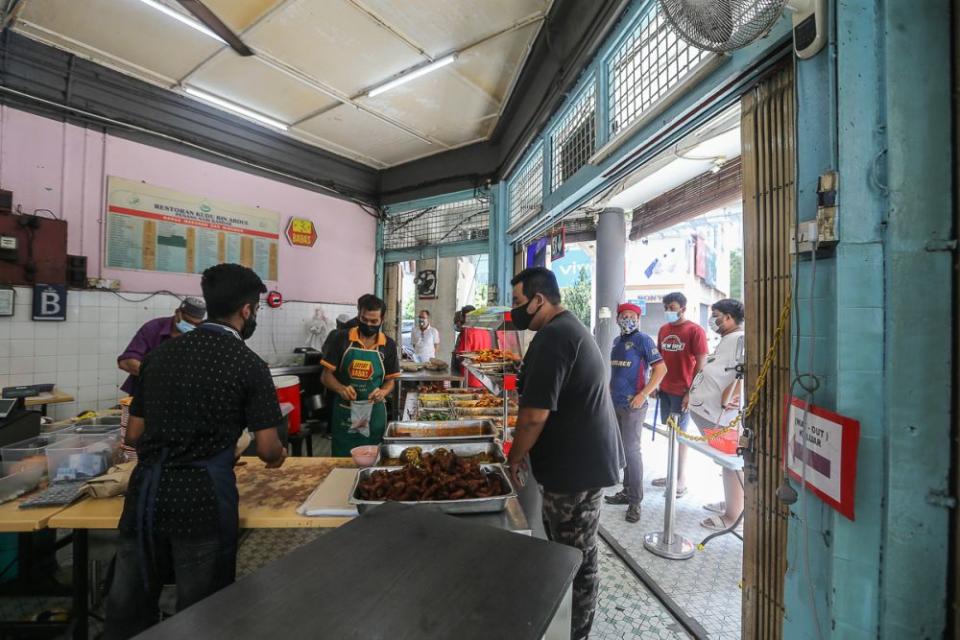 Members of the public queue to pack food at Restoran Kudu bin Abdul in Kuala Lumpur June 14, 2021. — Picture by Yusof Mat Isa