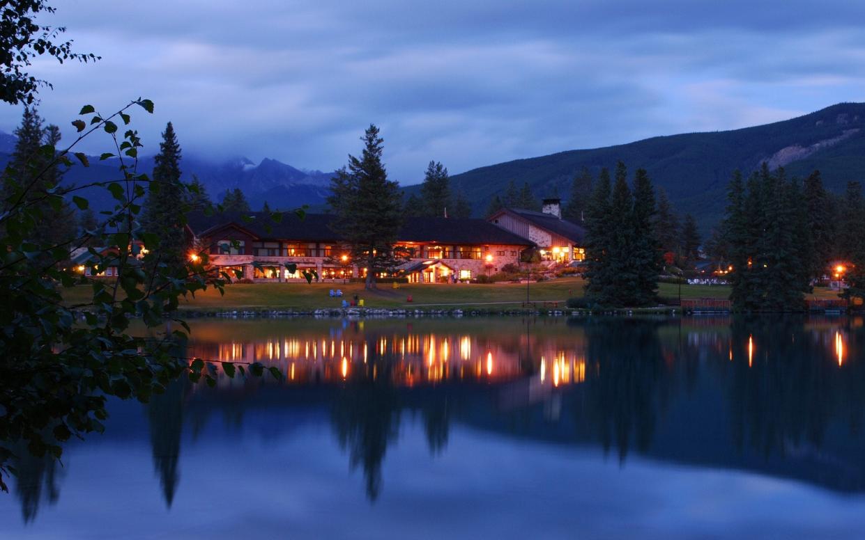 The historic Fairmont Jasper Park Lodge at dusk from across Lac Beauvert - All Canada Photos