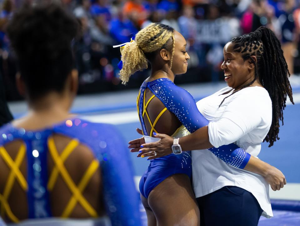Fisk gymnastics coach Corrinne Tarver, right, congratulates Alyssa Wiggins on her balance beam routine during a quad meet in Gainesville, FL., on Friday, January 12, 2024. In 2023, Fisk debuted the nation’s first HBCU gymnastics program.