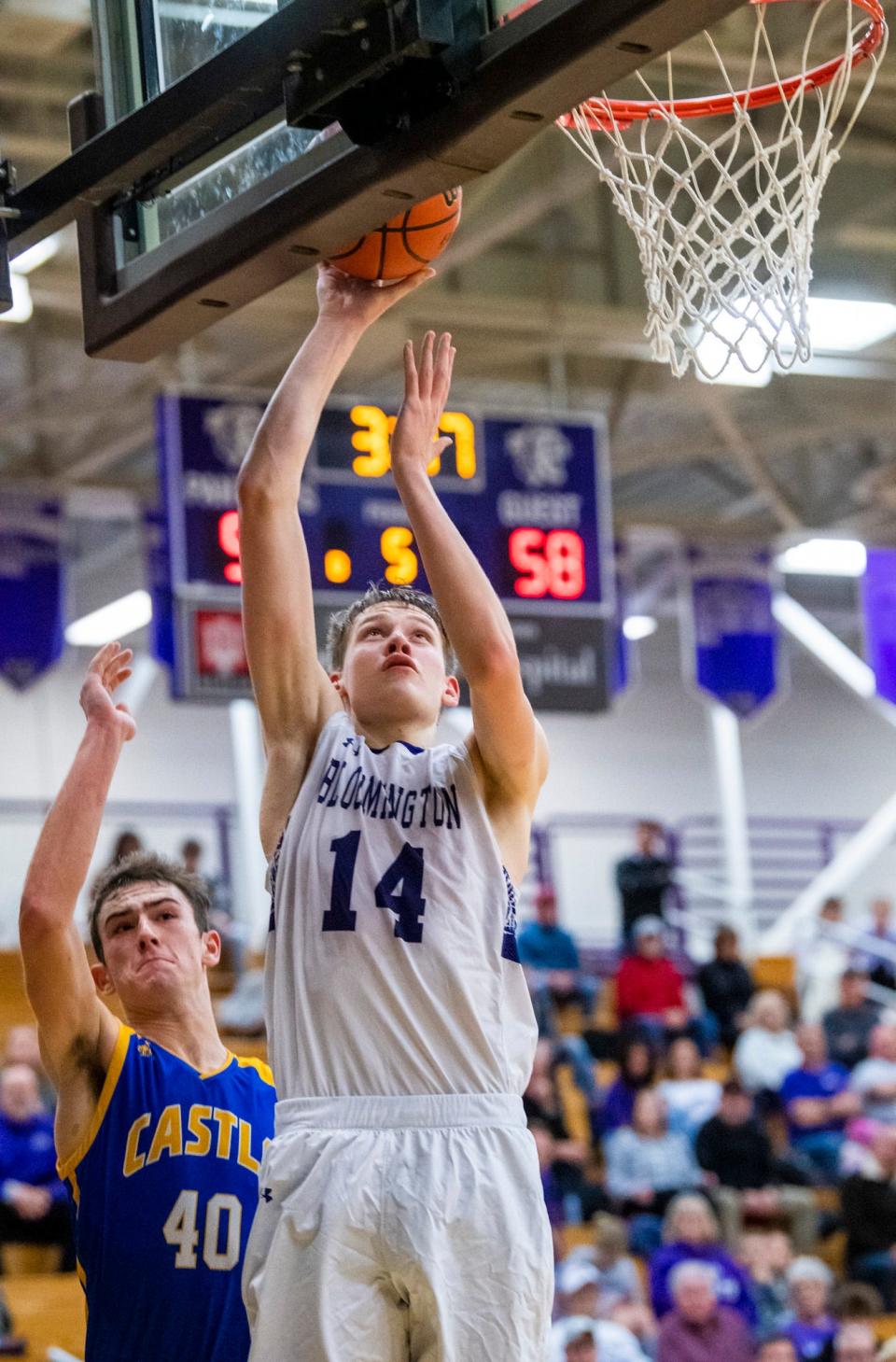 South's Gavin Wisely (14) scores in front of Castle's Weston Aigner (40) in overtime during the Bloomington South versus Castle boys basketball game at Bloomington High School South on Friday, Jan. 20, 2023.