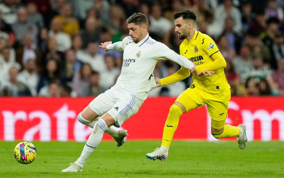 Villarreal's Alex Baena grabs Real Madrid's Federico Valverde by the shirt during a Spanish La Liga soccer match between Real Madrid and Villarreal at the Santiago Bernabeu stadium in Madrid - AP Photo/Jose Breton