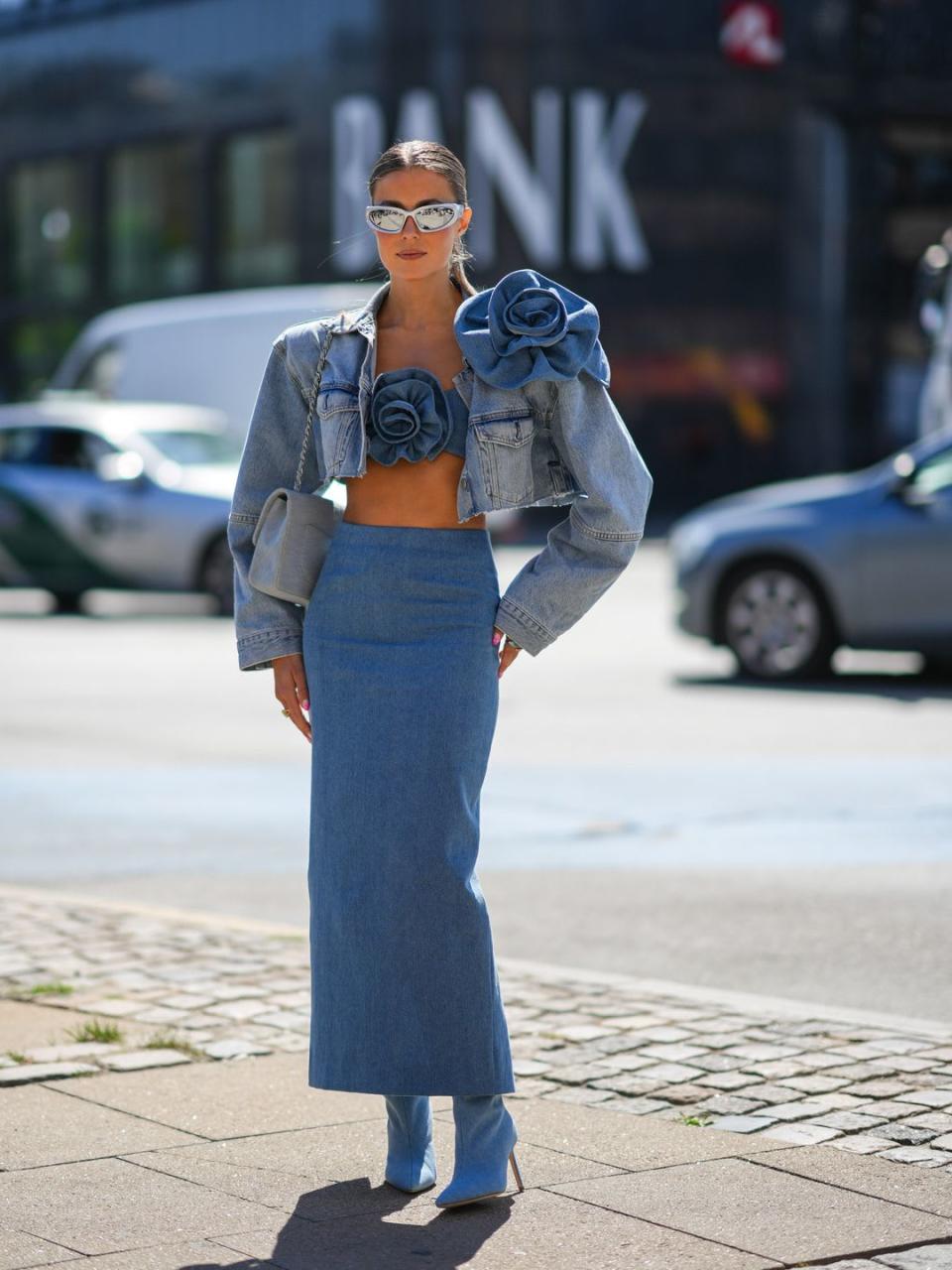 A Fashion Week guest a denim 3D floral crop top with a midi skirt 