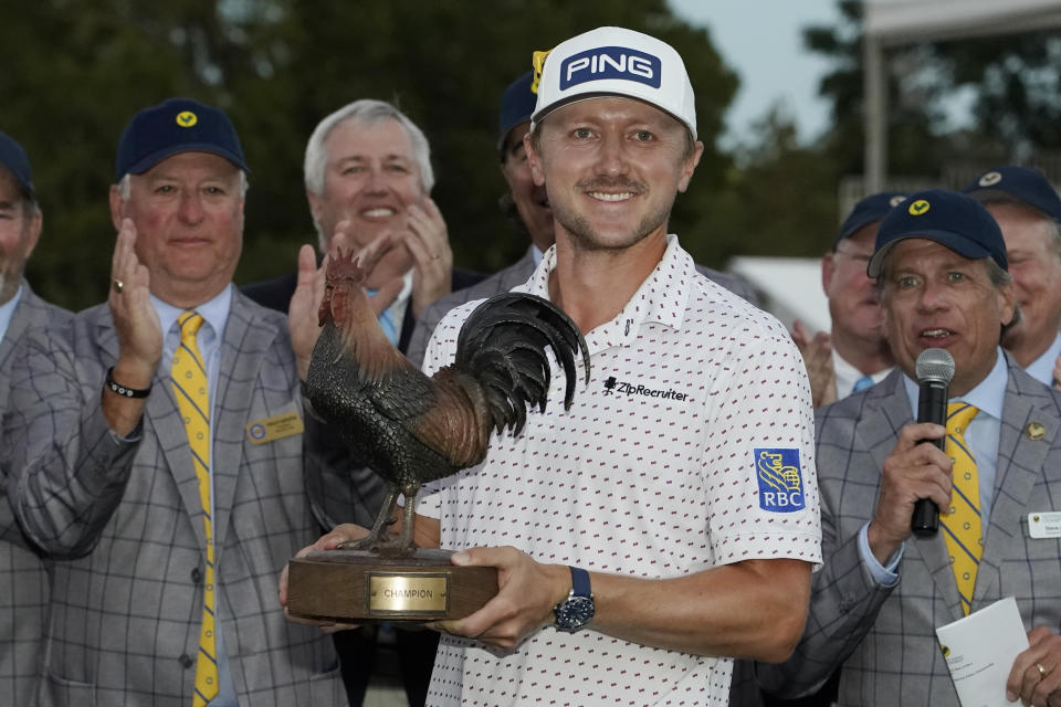 Mackenzie Hughes, of Canada, hoists the Sanderson Farms Championship golf tournament trophy in Jackson, Miss., Sunday, Oct. 2, 2022. Hughes won on the second hole of a sudden death playoff. (AP Photo/Rogelio V. Solis)