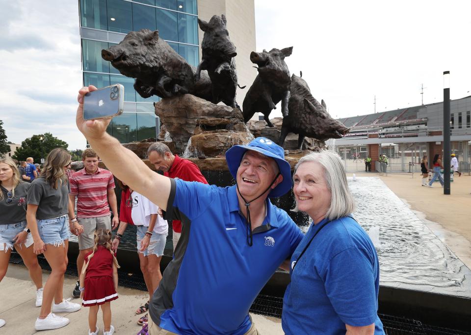 BYU fans Mick and Diane Smith take a selfie near the Razorback bronze at Razorback Stadium in Fayetteville on Saturday, Sept. 16, 2023. | Jeffrey D. Allred, Deseret News