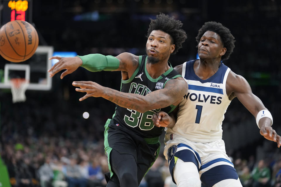 Boston Celtics guard Marcus Smart (36) passes the ball as Minnesota Timberwolves forward Anthony Edwards (1) tries to defend in the first half of an NBA basketball game, Sunday, March 27, 2022, in Boston. (AP Photo/Steven Senne)