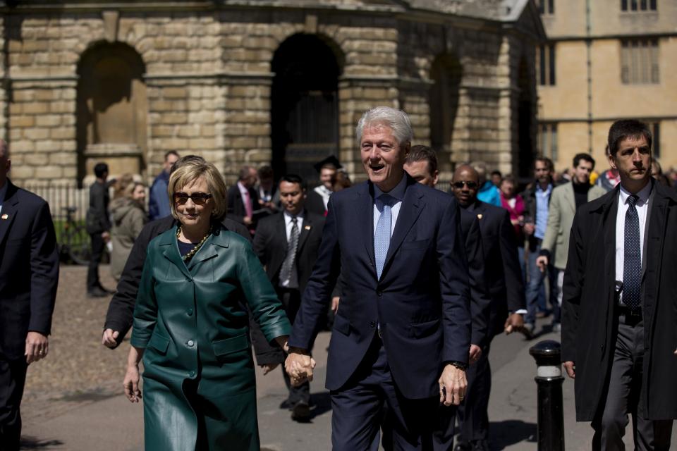 Former U.S. President Bill Clinton, center right, and his wife former Secretary of State Hillary Rodham Clinton walk away after they attended their daughter Chelsea's Oxford University graduation ceremony held at the Sheldonian Theatre in Oxford, England, Saturday, May 10, 2014. Chelsea Clinton received her doctorate degree in international relations on Saturday from the prestigious British university. Her father was a Rhodes scholar at Oxford from 1968 to 1970. The graduation ceremony comes as her mother is considering a potential 2016 presidential campaign. (AP Photo/Matt Dunham)