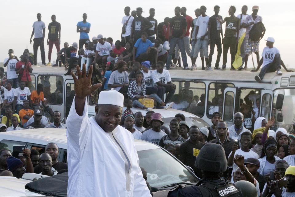 FILE - In this Thursday Jan. 26, 2017 file photo, Gambia President Adama Barrow waves as he rides his motorcade through crowds of hundreds of thousands after arriving at Banjul airport in Gambia, after flying in from Dakar, Senegal. Gambia's new president is set to be inaugurated Saturday Feb. 18, 2017, as this tiny West African nation celebrates wider freedoms after a tense political standoff with its former leader. (AP Photo/Jerome Delay, File)