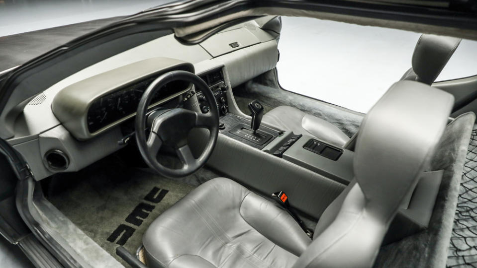 The interior features gray bucket seats, power windows, air conditioning and even the original DMC radio with cassette player. - Credit: Worldwide Auctioneers