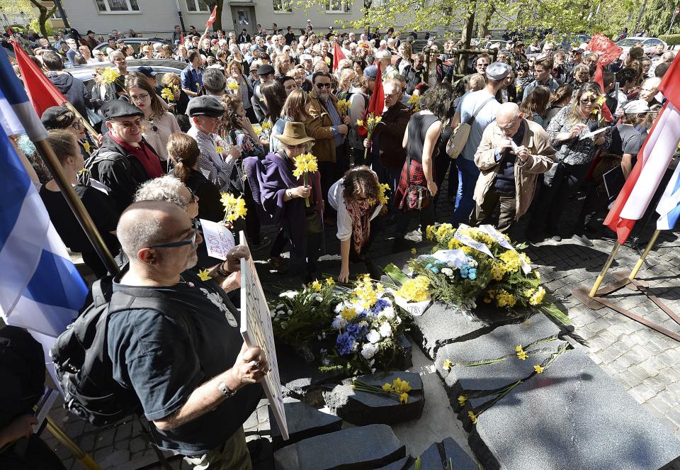 Warsaw residents lay daffodils, which have become the symbol of remembrance of the 1943 Warsaw Ghetto Uprising against the German Nazi, at a memorial site of the struggle, during anniversary observances in Warsaw, Poland, Friday, April 19, 2019. (AP Photo/Czarek Sokolowski)