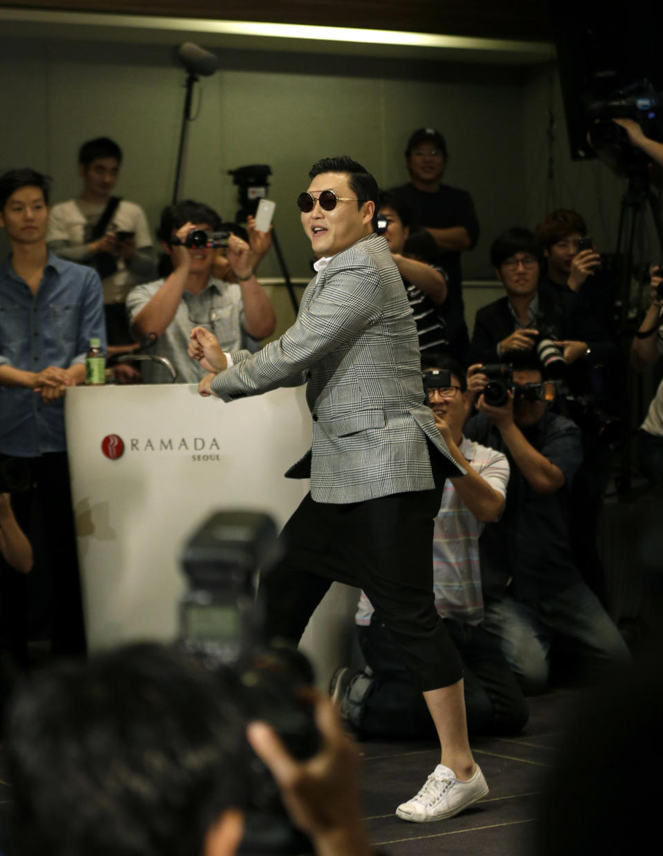 South Korean rapper PSY, who sings the popular "Gangnam Style" song, dances as he leaves his press conference in Seoul, South Korea, Tuesday, Sept. 25, 2012. (AP Photo/Lee Jin-man)