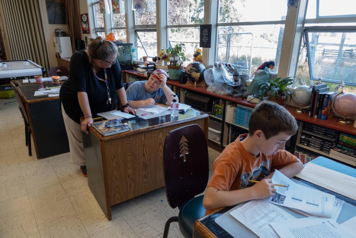 Greta Turney helps sixth-grader Asha Quinlan during class at Kneeland School.