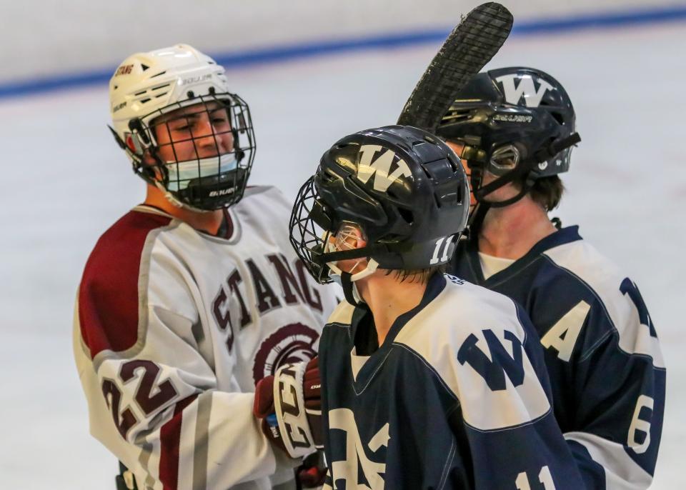 Bishop Stang's Quinn Pine and Nantucket's Hunter Strojny and Cole Evens exchange pleasantries at the end of the second period.