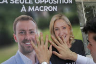 FILE - A supporter of French far-right leader Marine Le Pen puts up a campaign poster in Aulnoy-Lez-Valenciennes, northern France, Friday, June 3, 2022. French voters were choosing lawmakers in a parliamentary election Sunday, June 12, 2022 as President Emmanuel Macron seeks to secure his majority while under growing threat from a leftist coalition. (AP Photo/Michel Spingler, File)