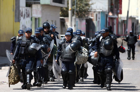 Police officers patrol a street after a blockade set by members of the Santa Rosa de Lima Cartel to repel security forces during an anti-fuel theft operation in Santa Rosa de Lima, in Guanajuato state, Mexico, March 6, 2019. REUTERS/Edgard Garrido