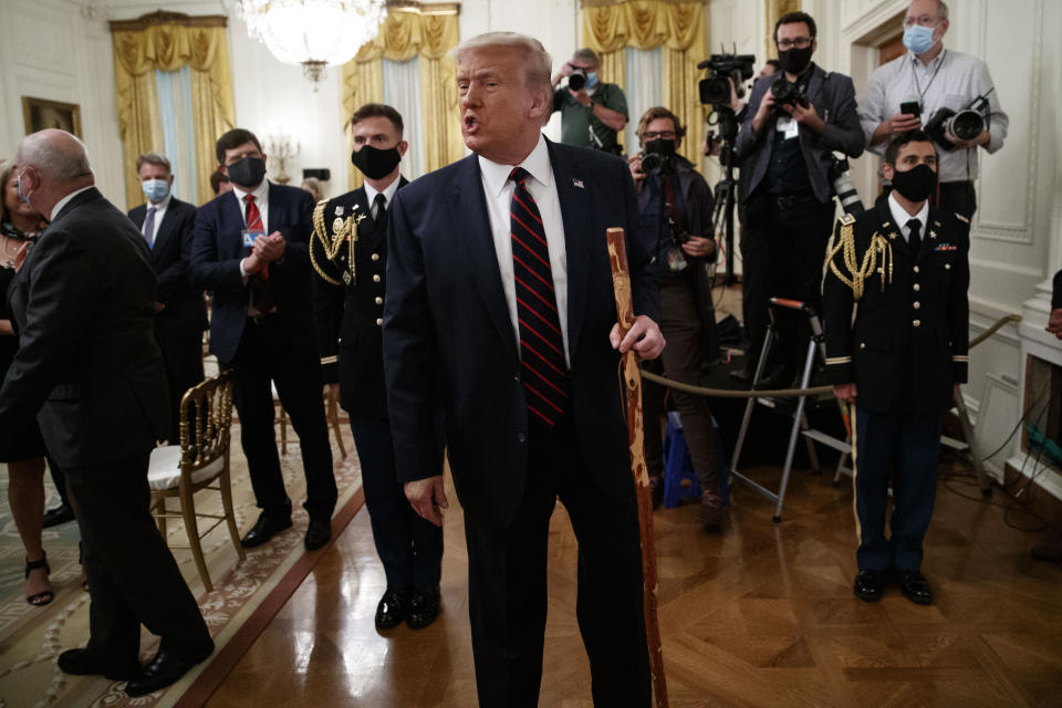 President Donald Trump departs carrying a walking stick given to him by Sen. Lamar Alexander, R-Tenn., after a signing ceremony for H.R. 1957 – "The Great American Outdoors Act," in the East Room of the White House, Tuesday, Aug. 4, 2020, in Washington. (AP Photo/Alex Brandon)