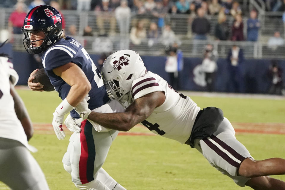 Mississippi quarterback Jaxson Dart (2) is tackled for a loss by a Mississippi State defender during the first half of an NCAA college football game in Oxford, Miss., Thursday, Nov. 24, 2022. (AP Photo/Rogelio V. Solis)