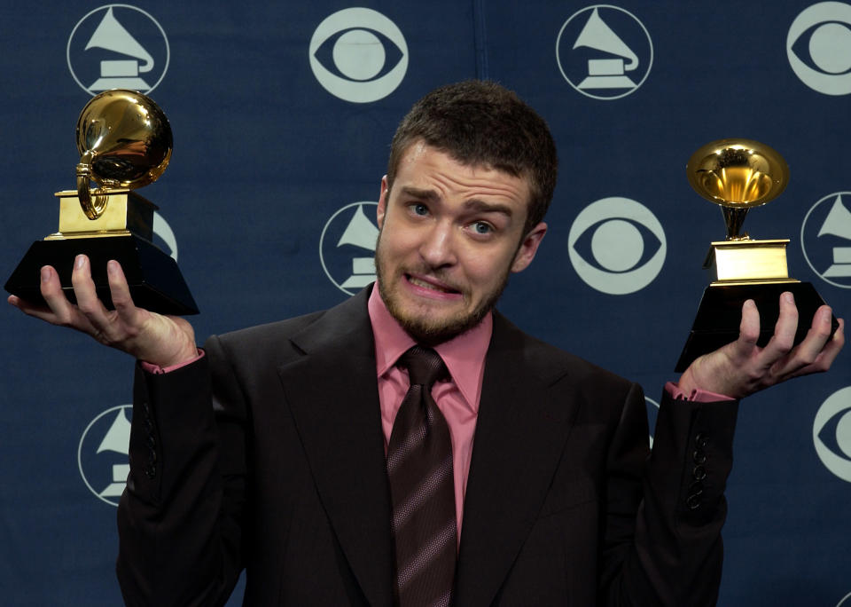 Justin Timberlake reacts as he holds the awards he won for best male pop vocal performance and best pop vocal album at the 46th Annual Grammy Awards, Sunday, Feb. 8, 2004, in Los Angeles. (AP Photo/Reed Saxon)