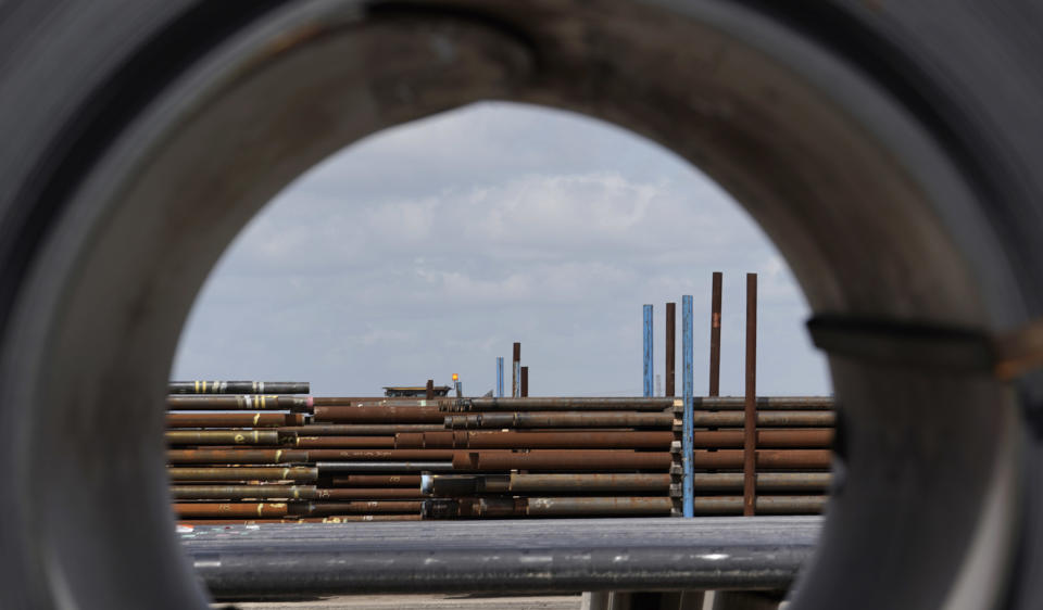 FILE- In this June 5, 2018, file photo steel pipes are seen through a roll of steel at the Borusan Mannesmann Pipe manufacturing facility in Baytown, Texas. Ditching decades of U.S. trade policy that he says swindled America and robbed its workers, President Donald Trump insists he can save U.S. jobs and factories by abandoning or rewriting trade deals, slapping taxes on imports and waging a brutal tariff war with China, America’s biggest trading partner. Separately Trump has enraged U.S. allies like Canada and the European Union by declaring their steel and aluminum a threat to America’s national security as justification for slapping taxes on them. (AP Photo/David J. Phillip, File)