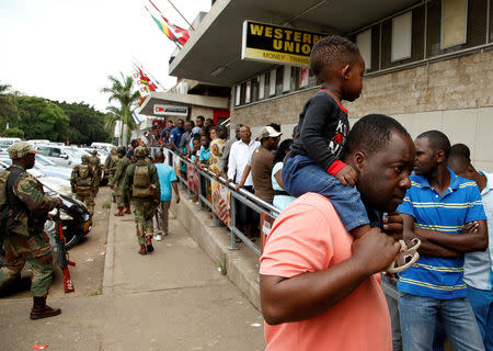 Armed soldiers patrol as people queue to shop at a supermarket in Harare, Zimbabwe, January 16, 2019. REUTERS/Philimon Bulawayo