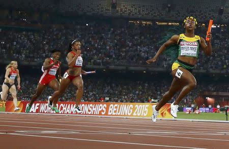 Shelly-Ann Fraser-Pryce of Jamaica (R) crosses the finish line ahead of Jasmine Todd of the U.S. (2nd R) to win the women's 4 x 100 metres relay final during the 15th IAAF World Championships at the National Stadium in Beijing, China, August 29, 2015. REUTERS/Kai Pfaffenbach