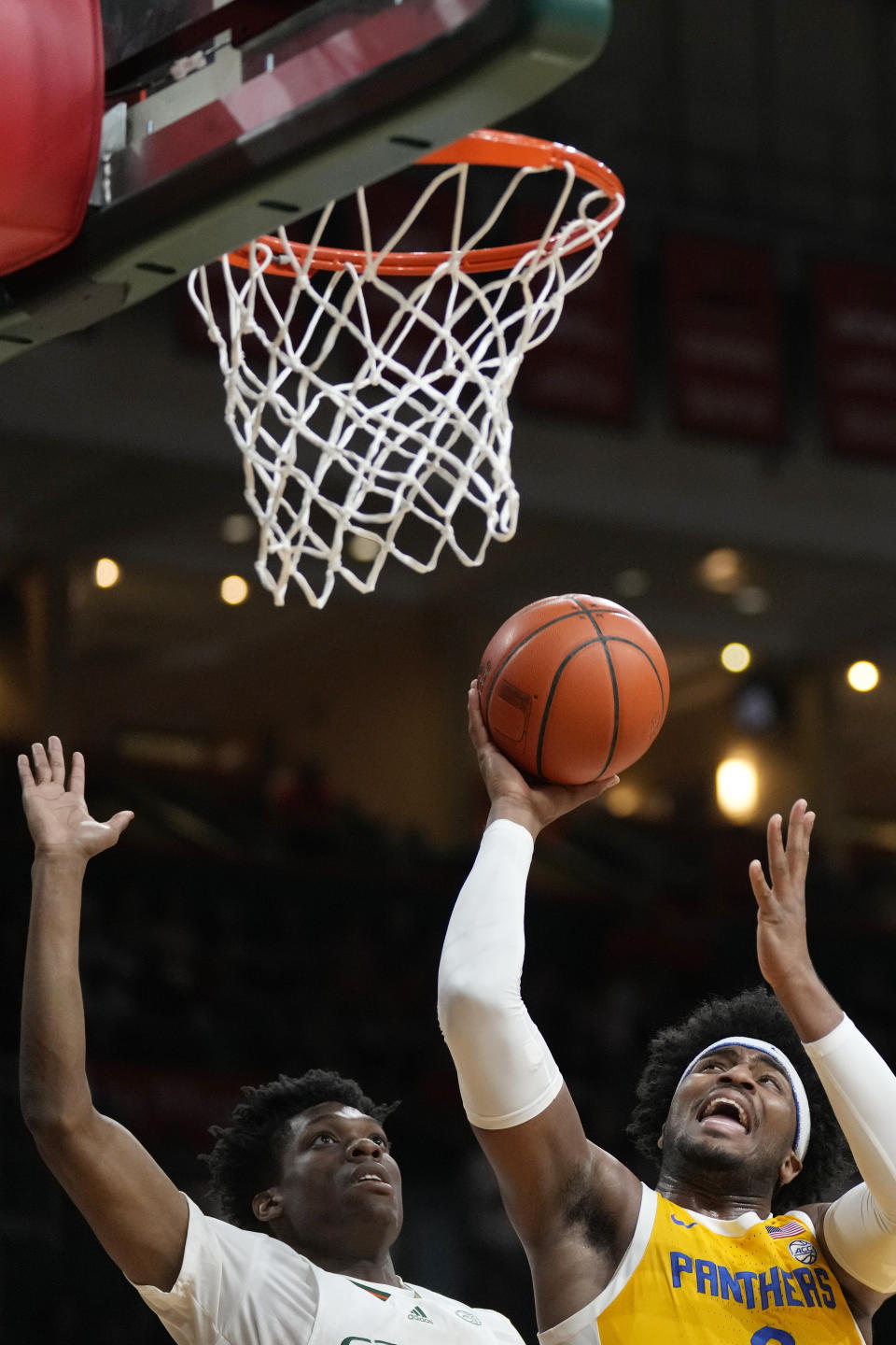 Pittsburgh forward Blake Hinson, right, shoots against Miami forward Anthony Walker during the first half of an NCAA college basketball game Saturday, March 4, 2023, in Coral Gables, Fla. (AP Photo/Rebecca Blackwell)