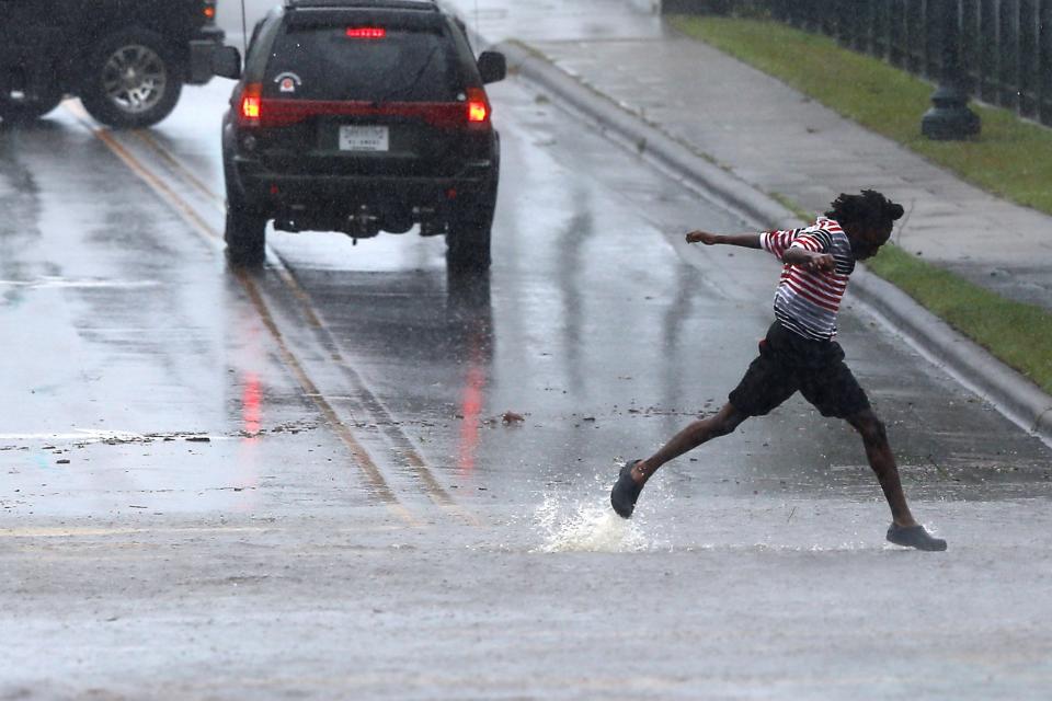 A pedestrian crosses the street during the heavy rain of outer bands of Hurricane Florence in New Bern on Thursday.