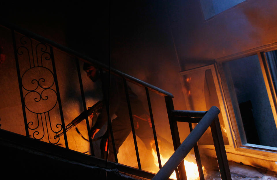 <p>A libyan rebel fighter runs up a burning stairwell during an effort to dislodge some ensconced government loyalist troops who were firing on them from an upstairs room during house-to-house fighting on Tripoli Street in downtown Misrata April 20, 2011 in Misrata, Libya. (Photo by Chris Hondros/Getty Images) </p>