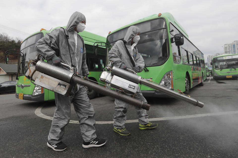 Workers wearing protective suits spray disinfectant as a precaution against the coronavirus at a bus garage in Seoul, South Korea, Wednesday, Feb. 26, 2020. The number of new virus infections in South Korea jumped again Wednesday and the U.S. military reported its first case among its soldiers based in the Asian country, with his case and many others connected to a southeastern city with an illness cluster. (AP Photo/Ahn Young-joon)