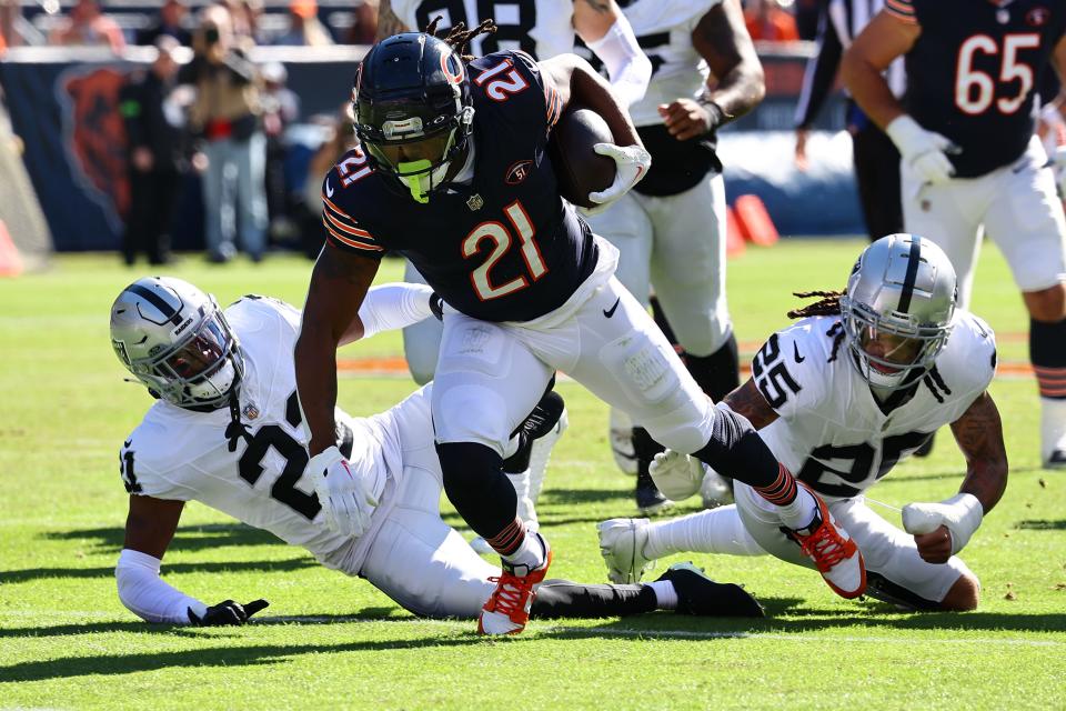 Chicago Bears running back D'Onta Foreman (21) rushes the ball past Las Vegas Raiders safety Tre'von Moehrig (25) in the first half of the game at Soldier Field.