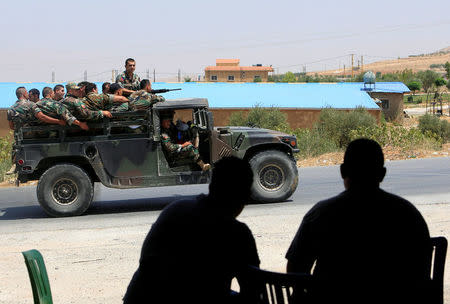 People watch as Lebanese army soldiers patrol a street in Labwe, at the entrance of the border town of Arsal, in Bekaa Valley, Lebanon July 22, 2017. REUTERS/Ali Hashisho