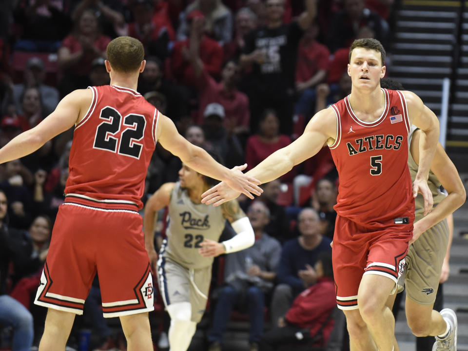 San Diego State forward Yanni Wetzell (5) slaps hands with guard Malachi Flynn (22) after scoring during the second half of an NCAA college basketball game against Nevada, Saturday, Jan. 18, 2020, in San Diego. (AP Photo/Denis Poroy)