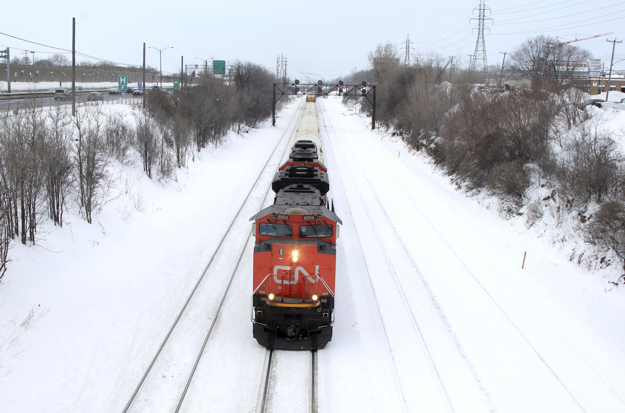 A Canadian National Railway train travels eastward on a track in Montreal, February 22, 2015. Canadian National Railway said on Sunday it is meeting with Unifor, the union representing 4,800 of its mechanical, clerical and intermodal staff, and hoped to reach a negotiated settlement or an agreement to enter binding arbitration over their contract dispute. Canada's No. 1 railway had called for binding arbitration on Friday when it first announced it was preparing to lock out employees represented by the union, a move it said could come as soon as Monday. REUTERS/Christinne Muschi (CANADA - Tags: BUSINESS EMPLOYMENT TRANSPORT)