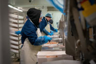 In this Tuesday, Jan. 28, 2020 photo, workers at the local fishing cooperative pack langoustines ready to be shipped to Italy, in Kilkeel harbor in Northern Ireland. The United Kingdom and the European Union are parting ways on Friday and one of the first issues to address is what will happen to the fishing grounds they shared. (AP Photo/David Keyton)