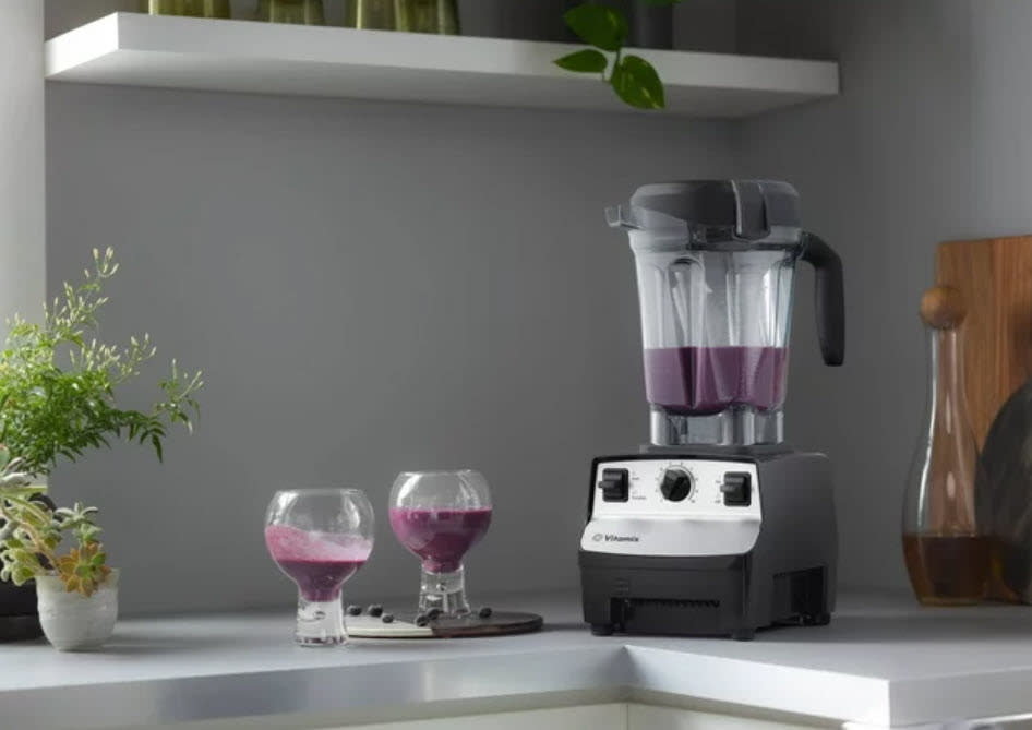 Blender on kitchen counter with two glasses of smoothie next to it