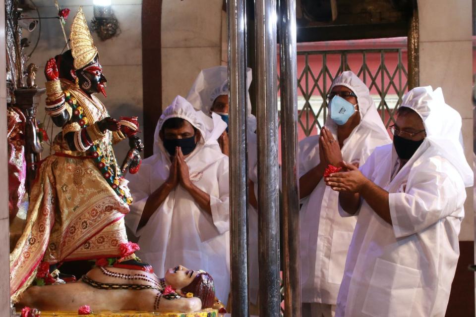 <span class="caption">Hindu priests wearing protective gear perform rituals in front of the Hindu goddess Kali.</span> <span class="attribution"><a class="link " href="https://www.gettyimages.com/detail/news-photo/hindu-priests-wearing-protective-gear-perform-rituals-in-news-photo/1219281994?adppopup=true" rel="nofollow noopener" target="_blank" data-ylk="slk:Debajyoti Chakraborty/NurPhoto via Getty Images;elm:context_link;itc:0;sec:content-canvas">Debajyoti Chakraborty/NurPhoto via Getty Images</a></span>