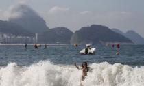 A woman enjoys on Copacabana beach with the Sugarloaf mountain in the background in Rio de Janeiro, Brazil, July 30, 2015. REUTERS/Sergio Moraes