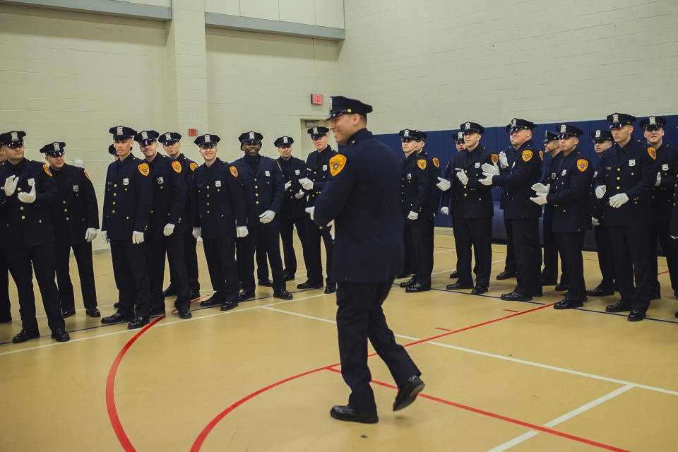 Matias Ferreira, center, arrives as his colleagues salute him while they prepare to march during their graduation from the Suffolk County Police Department Academy at the Health, Sports and Education Center in Suffolk, Long Island, New York, Friday, March 24, 2017. Ferreira, a former U.S. Marine Corps lance corporal who lost his legs below the knee when he stepped on a hidden explosive in Afghanistan in 2011, is joining a suburban New York police department. The 28-year-old graduated Friday from the Suffolk County Police Academy on Long Island following 29 weeks of training. (AP Photo/Andres Kudacki)