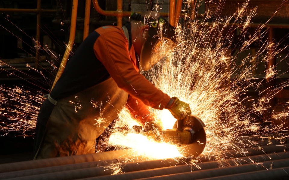 UK manufacturing: A worker cuts newly manufactured bars of steel