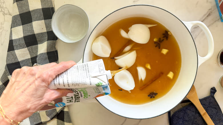 adding broth to pot for pho