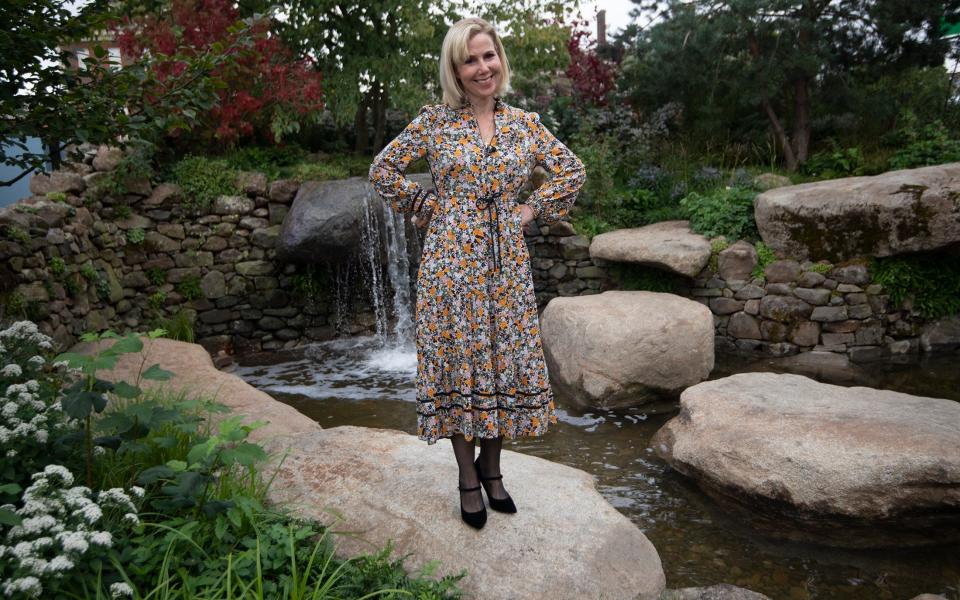 Sally Phillips stands in a garden