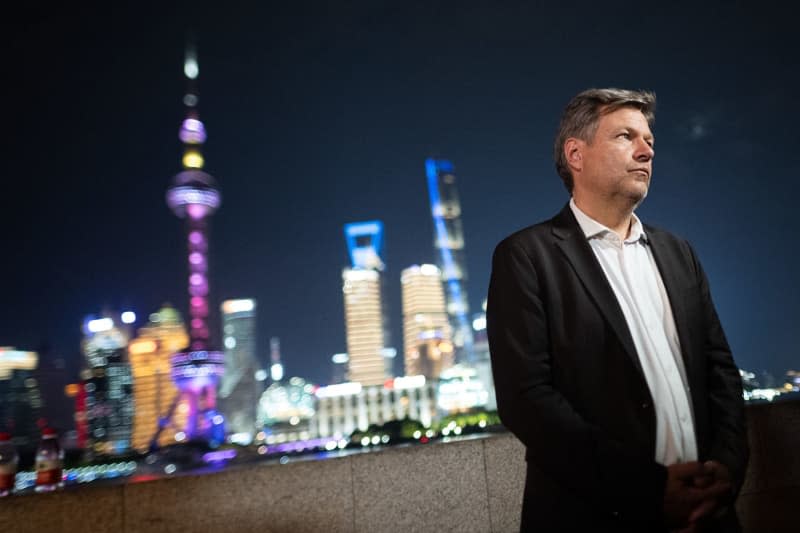 Robert Habeck, German Minister for Economic Affairs and Climate Protection, stands in front of the skyline on the waterfront promenade "The Bund" during a visit to China. Sebastian Christoph Gollnow/dpa