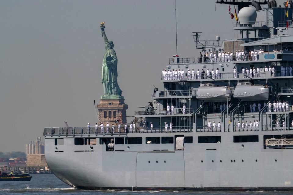 US Sailors and Marines stand on the flight deck of the USS Bataan, a Wasp-class amphibious assault ship, as it passes the Statue of Liberty during Fleet Week in New York Harbor on May 22, 2024.