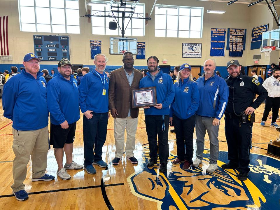 Hull High football coach Mike O'Donnell, fourth from right, and his coaching staff pose with New England Patriots and NFL Hall of Fame linebacker Andre Tippett after O'Donnell was named New England Patriots High School Coach of the Week on Tuesday, Nov. 29, 2022.