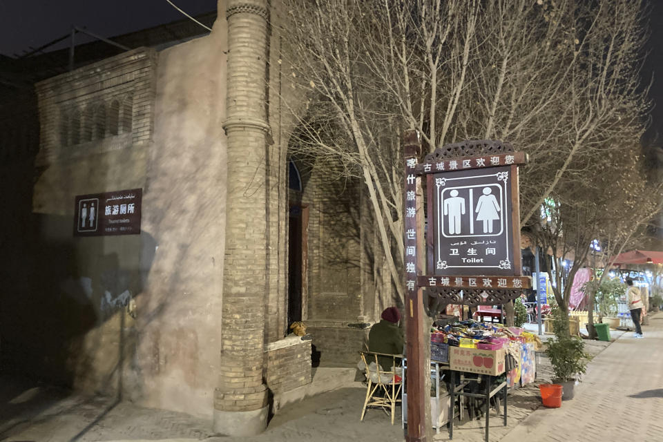 Vendors sell their goods by a section of a mosque converted into a tourist bathroom in Kashgar, in China's far west Xinjiang region, on March 19, 2021. Four years after Beijing's brutal crackdown on largely Muslim minorities native to Xinjiang, Chinese authorities are dialing back the region's high-tech police state and stepping up tourism. But even as a sense of normality returns, fear remains, hidden but pervasive. (AP Photo/Dake Kang)