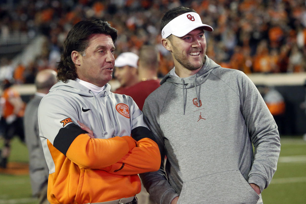 Oklahoma State head coach Mike Gundy, left, talks with Oklahoma head coach Lincoln Riley before their NCAA college football game in Stillwater, Okla., Saturday, Nov. 30, 2019. (AP Photo/Sue Ogrocki)