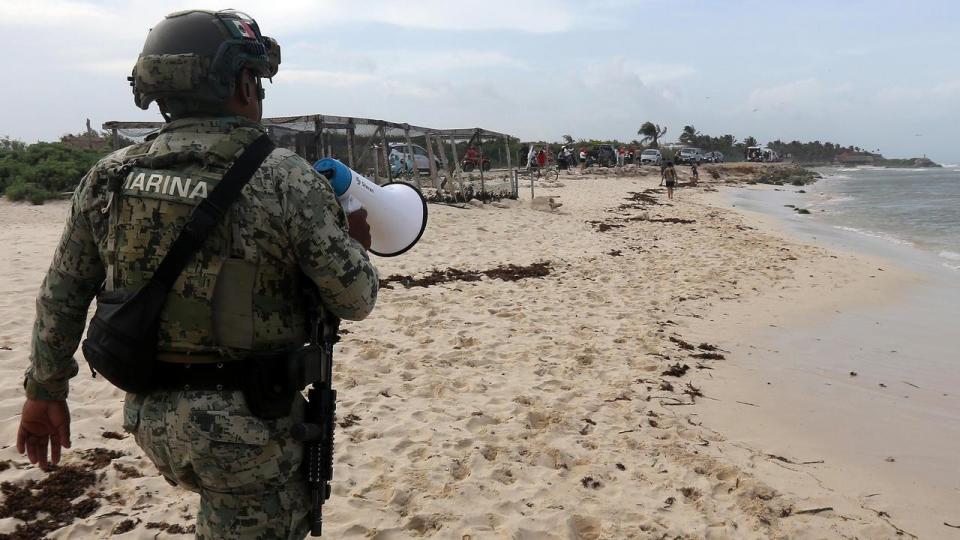 A soldier patrols a Mexican beach as Hurricane Beryl approaches