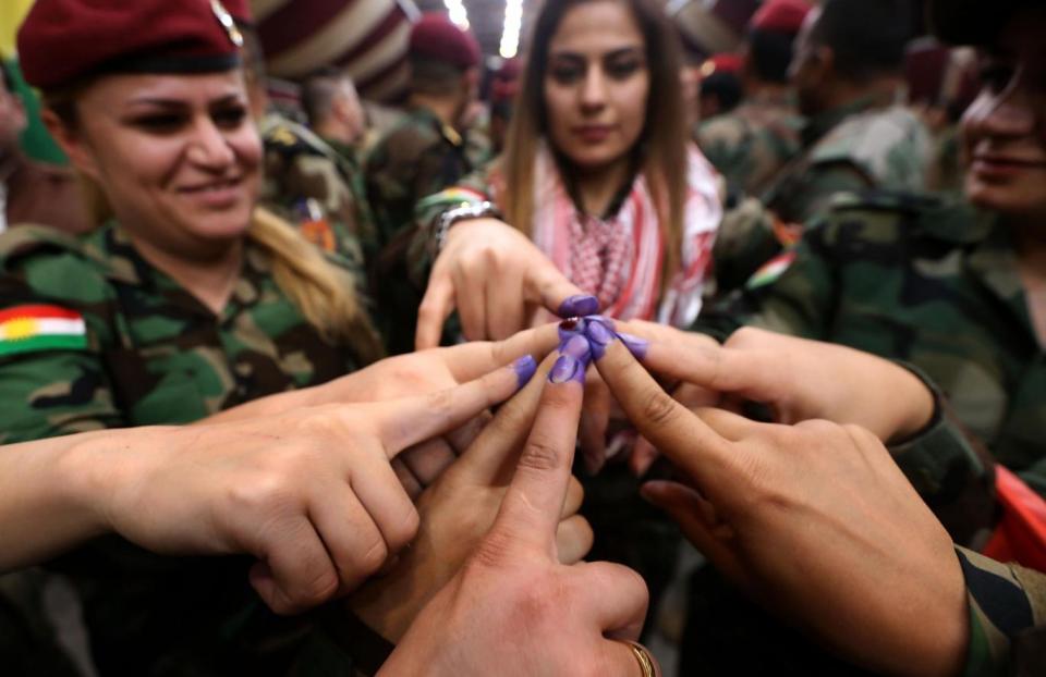 Members of a Kurdish Peshmerga battalion show their ink-stained fingers after casting their vote(AFP/Getty)