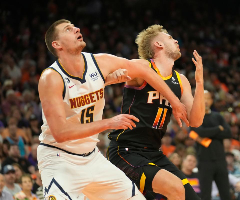 Phoenix Suns center Jock Landale (11) takes an elbow from Denver Nuggets center Nikola Jokic (15) during Game 6 of the Western Conference semifinals at Footprint Center in Phoenix on May 11, 2023.