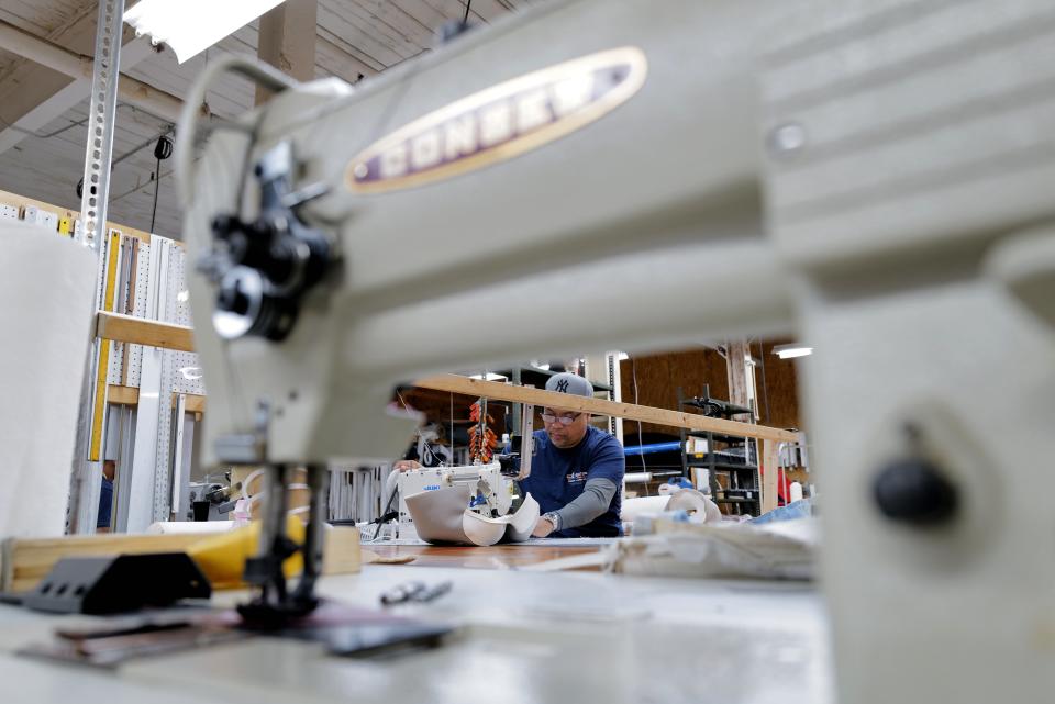 Cesar Abreu stitches some upholstery for a boat at Cesar Marine Canvas & Upholstery on Harbor Street in New Bedford.