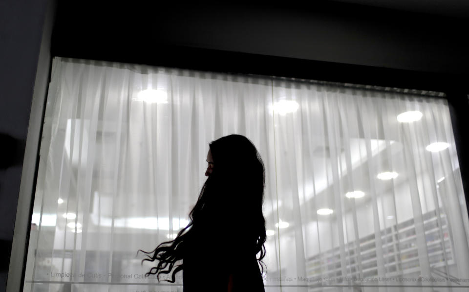 Valery Díaz poses for a photo in Caracas, Venezuela, Tuesday, April 2, 2019, before getting a section of it cut off and sold for $100. "There are times when you go two or three weeks without washing your hair," she said, alluding to frequent water shortages in past weeks, caused by nationwide blackouts that shut off water pumps. (AP Photo/Natacha Pisarenko)